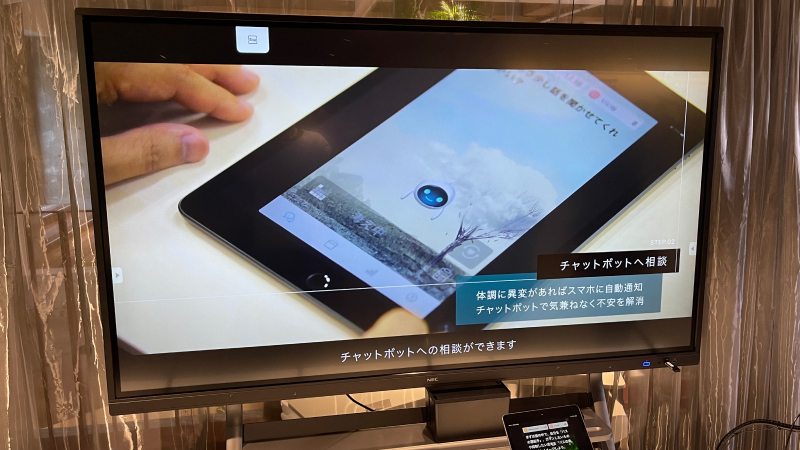 大型モニターにSELF MINDアプリが開かれた端末が写っている